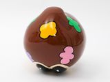 a chocolate egg decorated with colorful flowers on a white surface