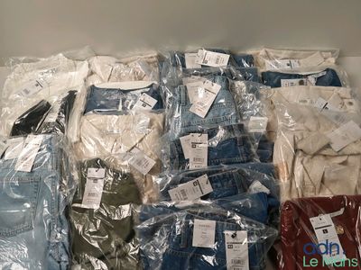 many different types of shirts and pants wrapped in plastic