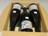 trois bouteilles de vin dans un carton avec une étiquette de prix