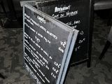 a menu board sitting on the floor of a restaurant