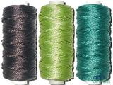 trois bobines de fil de différentes couleurs sur un fond blanc