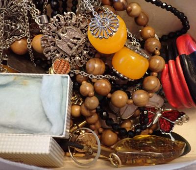 un bol blanc rempli d'un assortiment de perles et de colliers