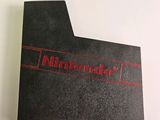 a close up of a nintendo logo on a black folder