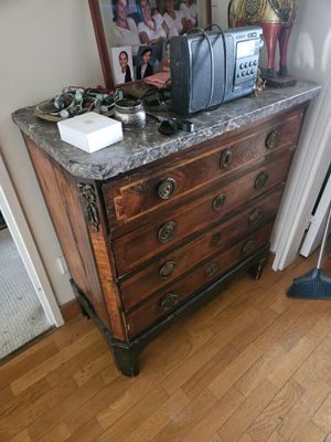 une commode en bois avec un plateau en marbre dans une chambre