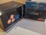 a microwave that is sitting on the counter next to a box of food