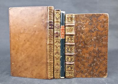 two old books sitting on top of each other on a table
