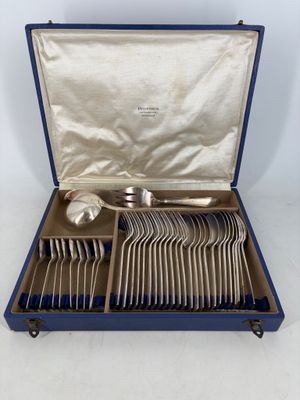 a set of silverware in a blue case on a white surface