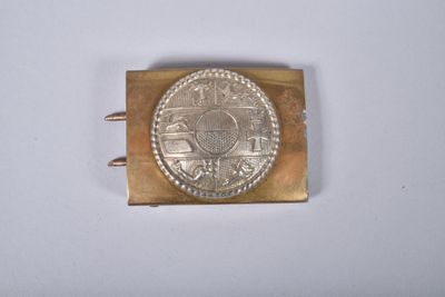 une boucle en or sur laquelle est posée une pièce d'argent