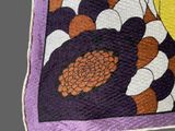 a close up of a quilt with a flower design on it
