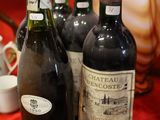 several bottles of wine are lined up on a red table cloth