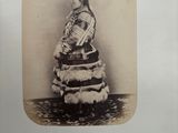 an old photo of a woman in a dress with a fan