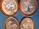 quatre photos encadrées représentant des fleurs dans un vase sur fond bleu