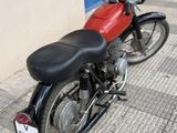 a red and black motorcycle parked next to a building
