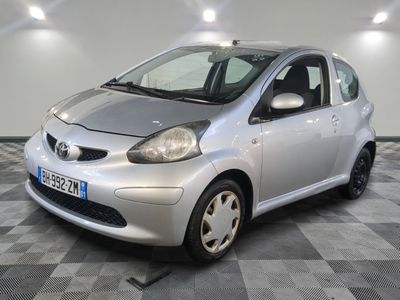 une photo d'une Toyota Aygo argentée garée sur un sol à damier