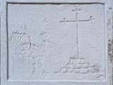 un gros plan d'une plaque en pierre sur laquelle figure une croix