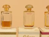 four bottles of perfume sitting on top of boxes on a table