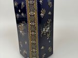 a blue vase with a gold border and flowers on it