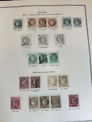 an open book with a bunch of stamps on it sitting on a table