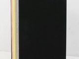 a black book sitting on top of a table next to a white wall