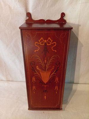 un petit meuble en bois orné d'un motif décoratif
