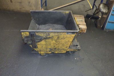 une caisse jaune posée sur une palette dans un garage