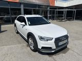 the white audi suv is parked in front of a building