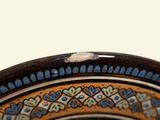 a close up of a decorative plate with a bird on it