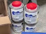 three cans of paint sitting on the floor next to a box