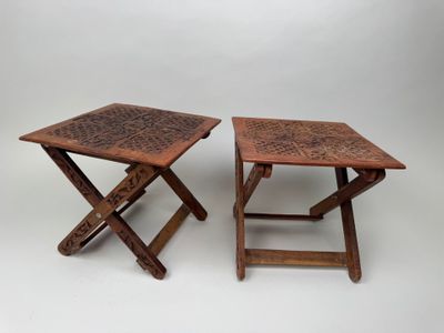 two small wooden tables with intricate designs on them on a white background