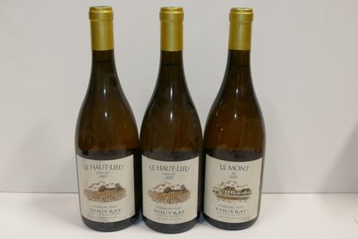 trois bouteilles de vin posées sur une table l'une à côté de l'autre