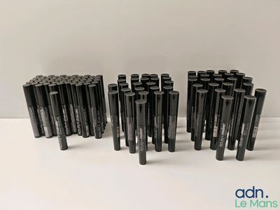 un groupe de stylos noirs posés sur une table blanche