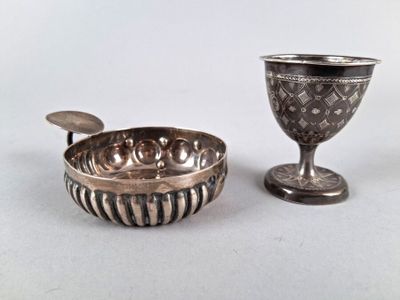 une coupe en argent et un bol en argent posés sur une table