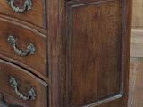 a small wooden chest of drawers on a hard wood floor