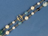 necklace with pearls and green glass beads on a blue background