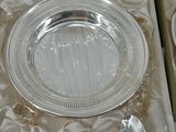 a silver plate in a box with a spoon and a spoon rest
