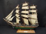 une maquette de voilier sur un support en bois