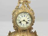 a gold clock sitting on top of a white table