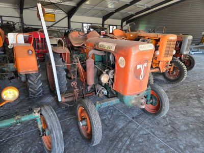 many old tractors parked in a garage together