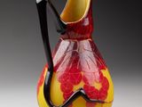 un vase rouge et jaune muni d'une anse noire