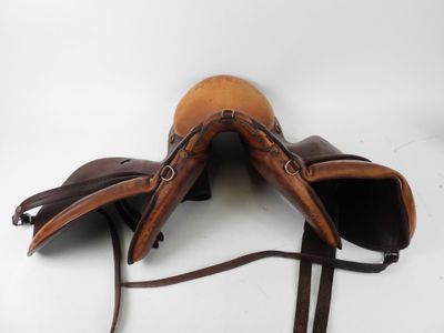 pair of brown leather saddles on a white background