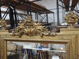 un miroir à cadre doré posé sur une table dans une pièce