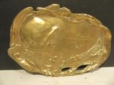 a gold plate with a fish on it sitting on a table