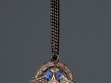 an image of a silver necklace with a blue and red emblem