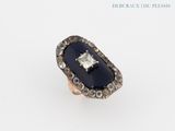 a close up of a ring on a white surface with diamonds