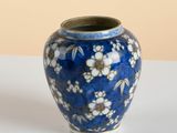 un vase bleu orné de fleurs blanches, posé sur une table