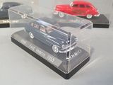 three models of cars in a display case on a table