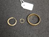 two gold rings and a ring with a price tag on a table