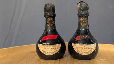 two bottles of wine sitting on top of a wooden table