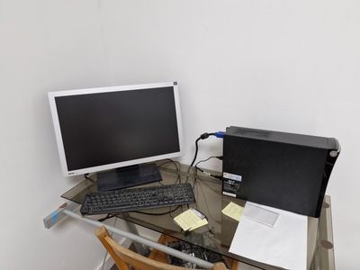 a glass desk with a computer and a keyboard on it