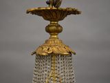 a gold and crystal chandelier with a bird on top